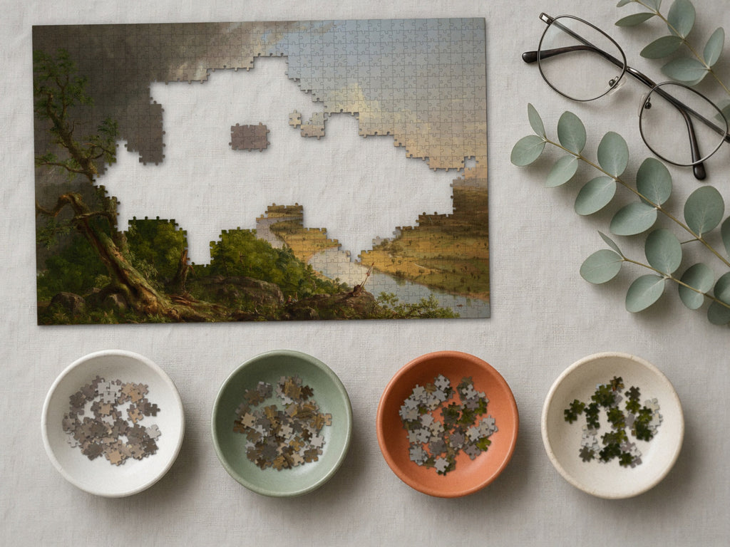 After the Storm Passed 1014 piece puzzle partly assembled on a linen cloth, loose pieces sorted into four small ceramic bowls beside reading glasses and eucalyptus