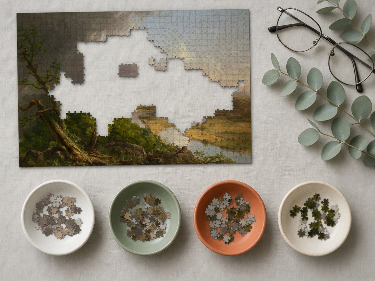 After the Storm Passed 1014 piece puzzle partly assembled on a linen cloth, loose pieces sorted into four small ceramic bowls beside reading glasses and eucalyptus