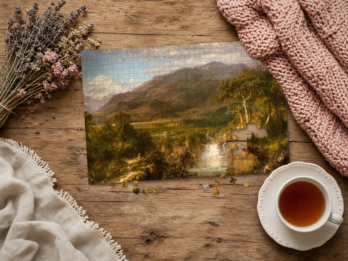 The Hidden Falls of the Andes 1014 piece puzzle assembled on a rustic wood table with dried lavender, a pink knit blanket, a linen throw and a cup of tea, a few loose pieces nearby