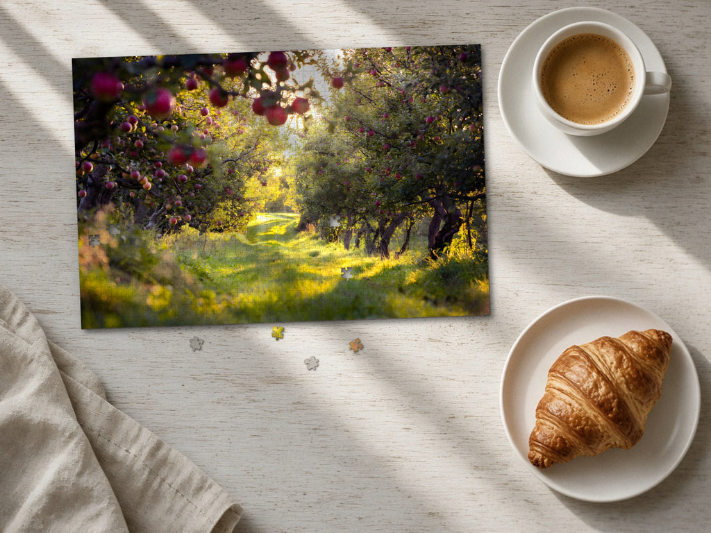 The Orchard Before the Harvest 1014 piece puzzle laid flat on a pale wood table in morning sun beside a cappuccino and a croissant