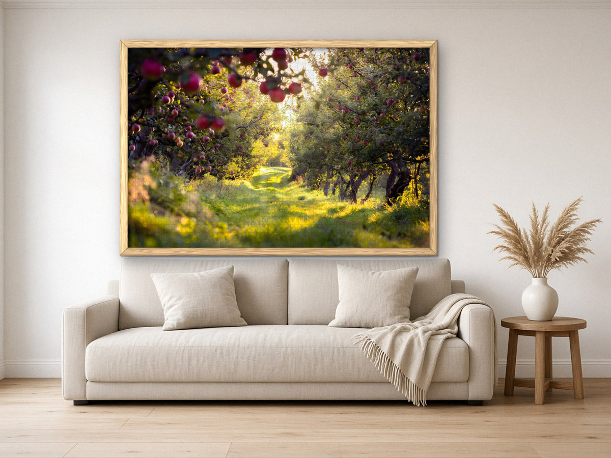 The Orchard Before the Harvest 1014 piece puzzle assembled, framed in light wood and hung above a cream sofa, with pampas grass on a side table