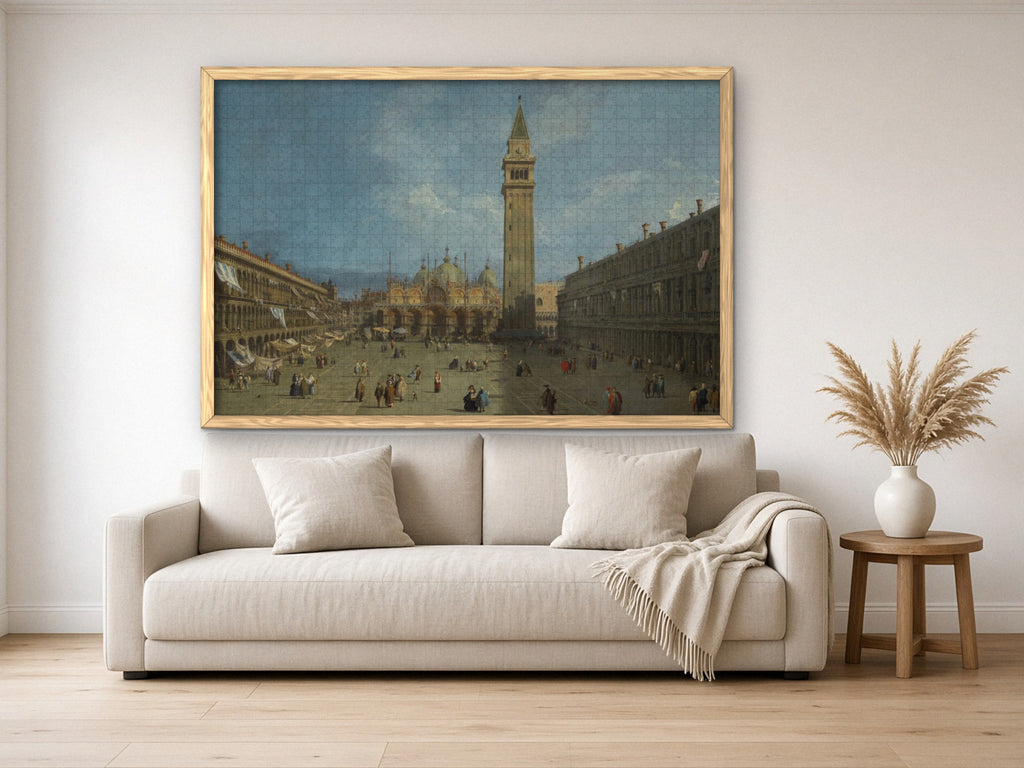 The Square Where Venice Waits 1014 piece puzzle assembled, framed in light wood and hung above a cream sofa, with pampas grass on a side table